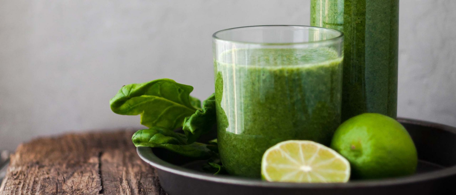 Perfekt für den Frühling Grüner Smoothie mit Limette und Spinat auf Holztisch