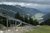 Sommerrodelbahn auf Berg mit Blick auf Tal und Berge unter bewölktem Himmel