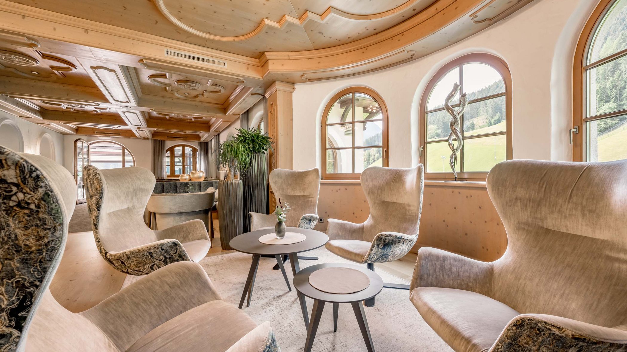 Hotel im Stubaital nahe Fulpmes Gemütliche Lounge mit gepolsterten Sesseln und großen Fenstern in Holzstil