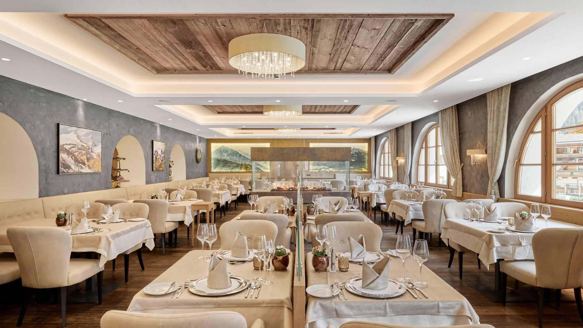 Stubai: l’hotel con piscina che cercavate è qui Ristorante elegante con tavoli apparecchiati e grandi finestre ad arco