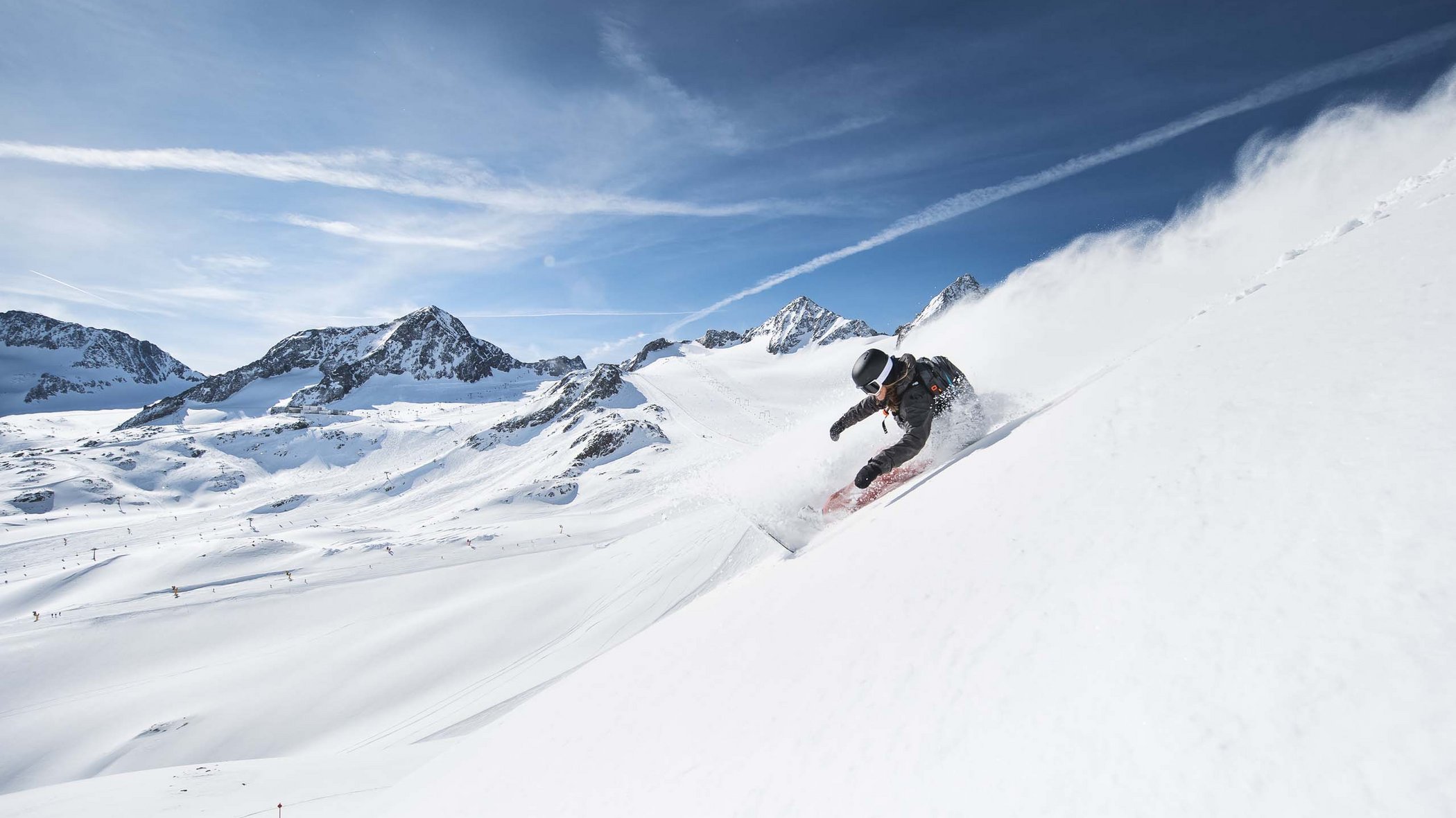 In Stubaital ci son mille cose da fare Snowboarder scende ripido su una montagna innevata sotto il sole