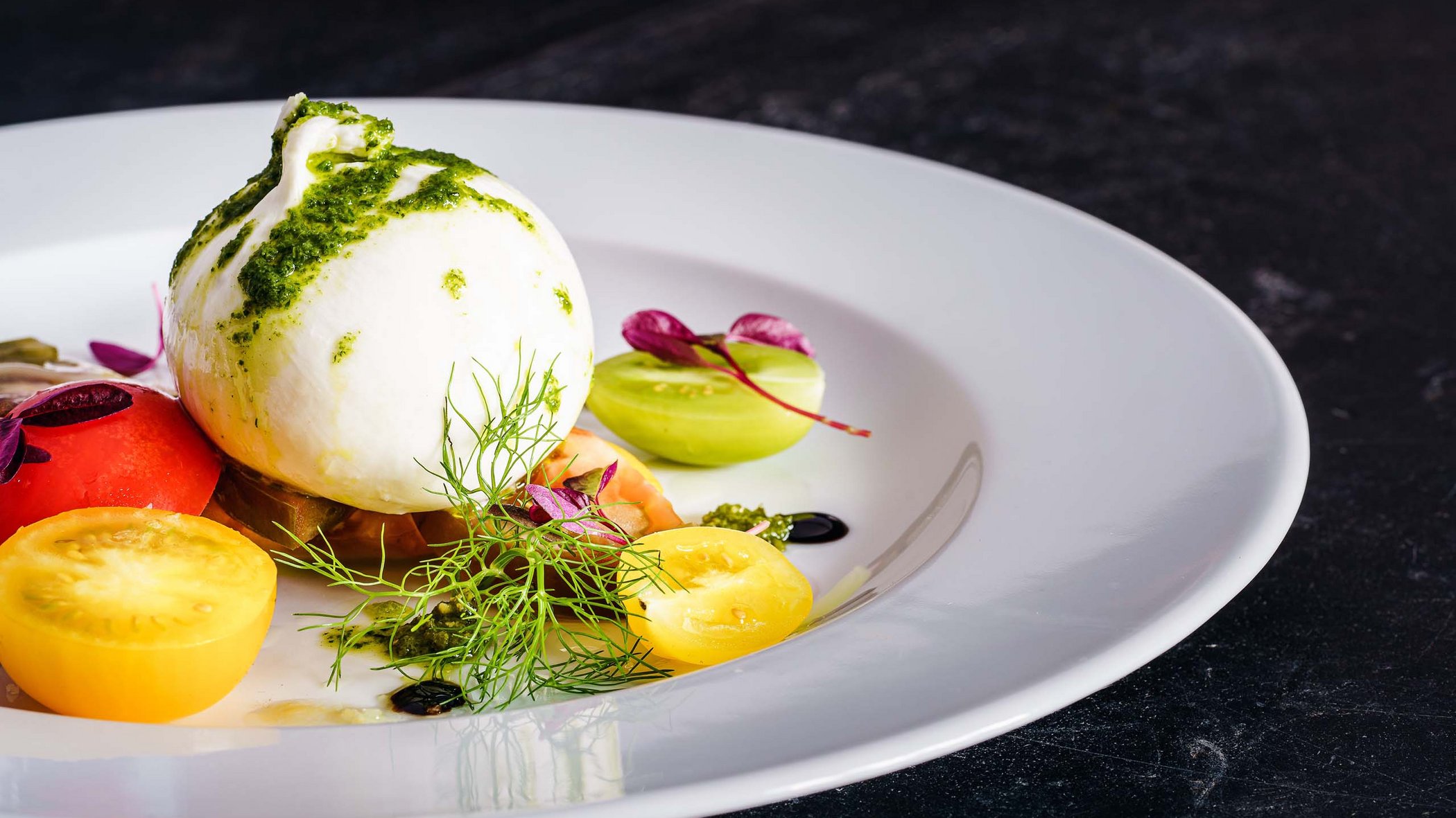 Hotels/Tyrol: 4-star superior holidays Burrata with cherry tomatoes and green pesto on white plate