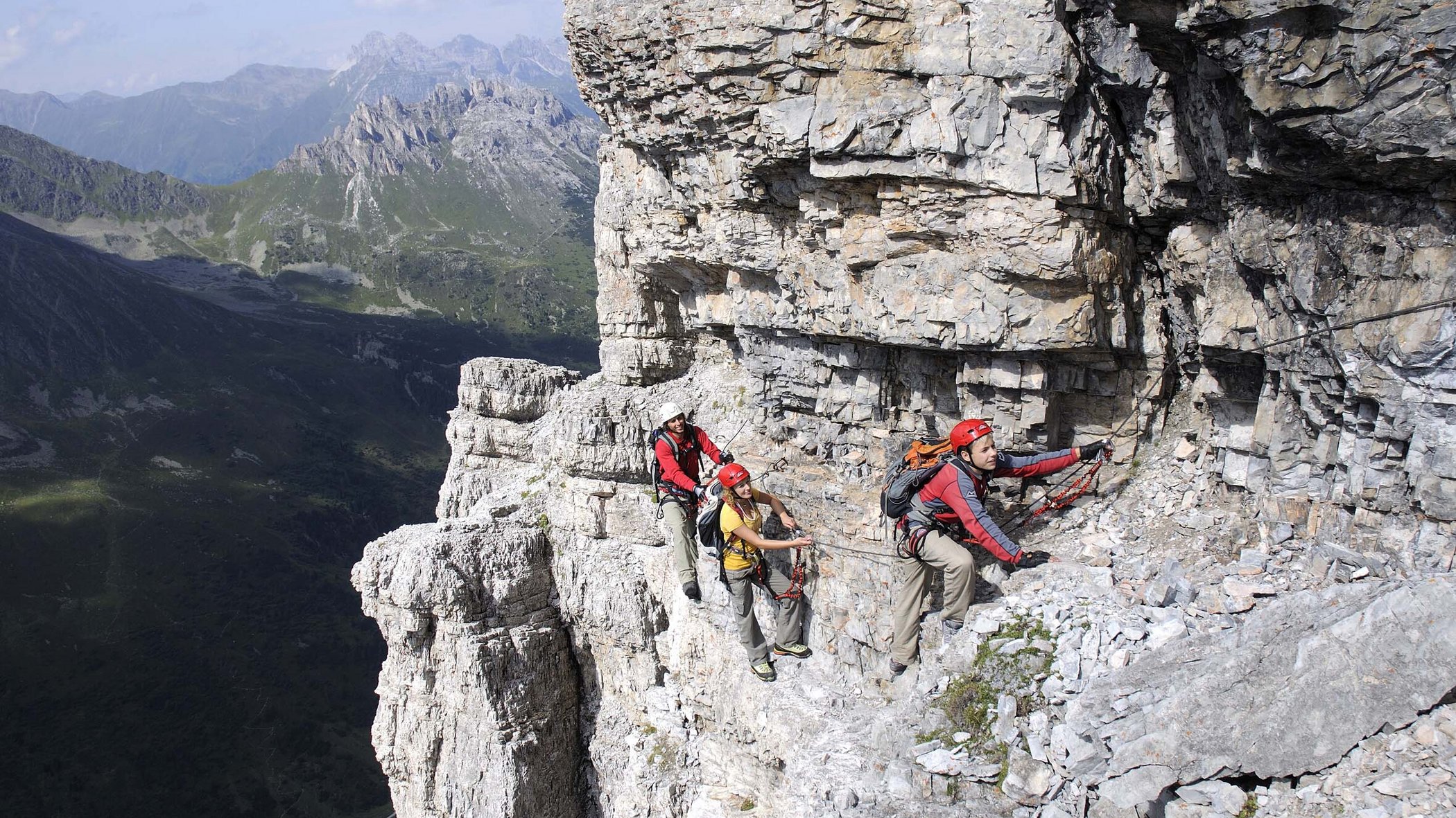 Neustift: the active hotel in Stubaital Three climbers secured on a steep rocky cliff in the mountains