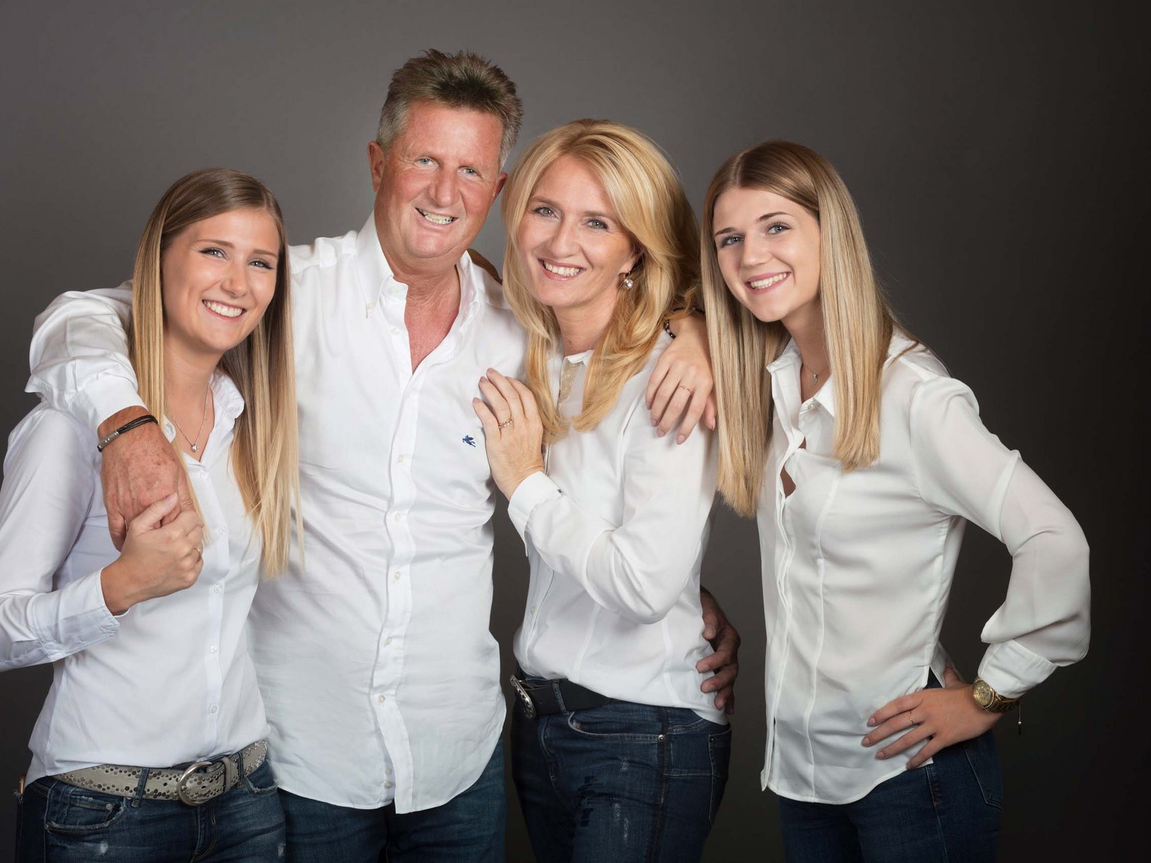 Stubaital: our hotel with a pool Happy family with father, mother, and two daughters wearing white shirts