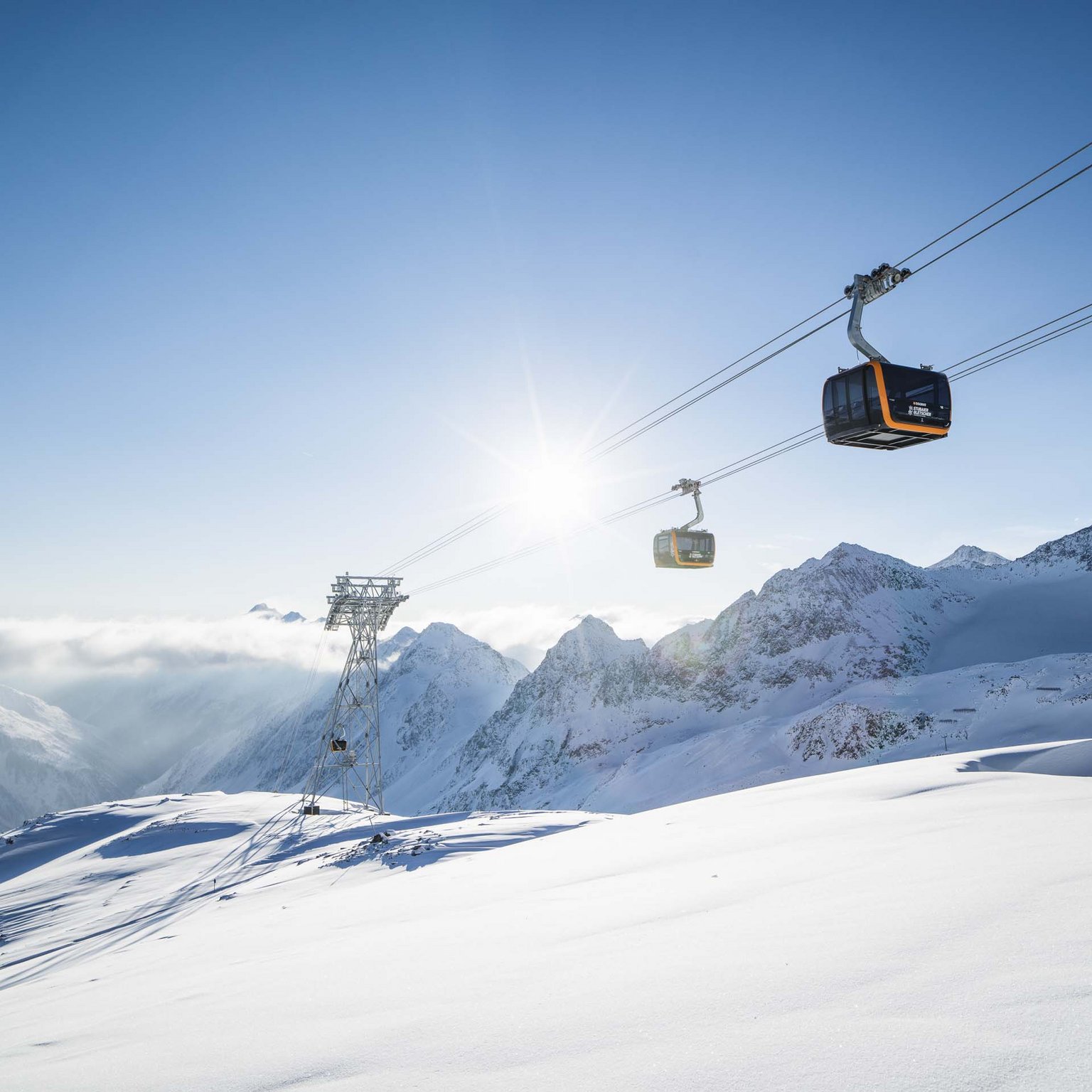 Der Stubaier Gletscher Seilbahnkabinen fahren über schneebedeckte Berge an einem sonnigen Wintertag