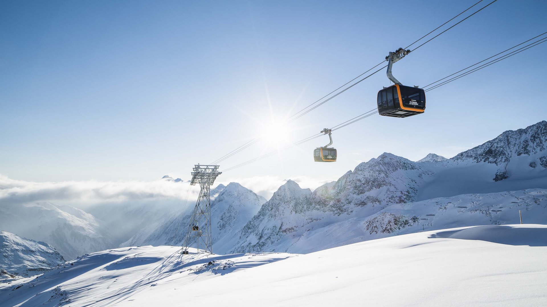 Skiing in Stubaital: offers Cable car cabins above snowy mountains on a sunny winter day