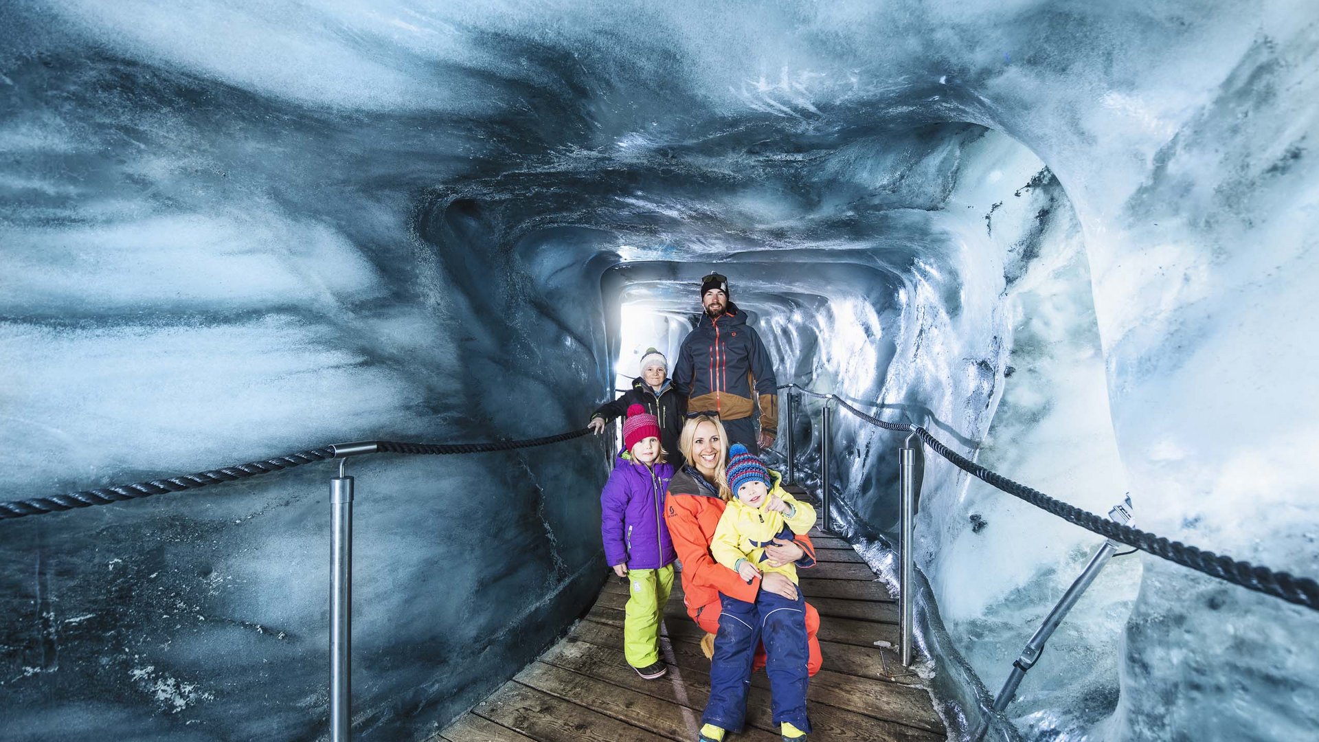 Things to do in Stubaital Family with children inside an ice cave on a wooden walkway