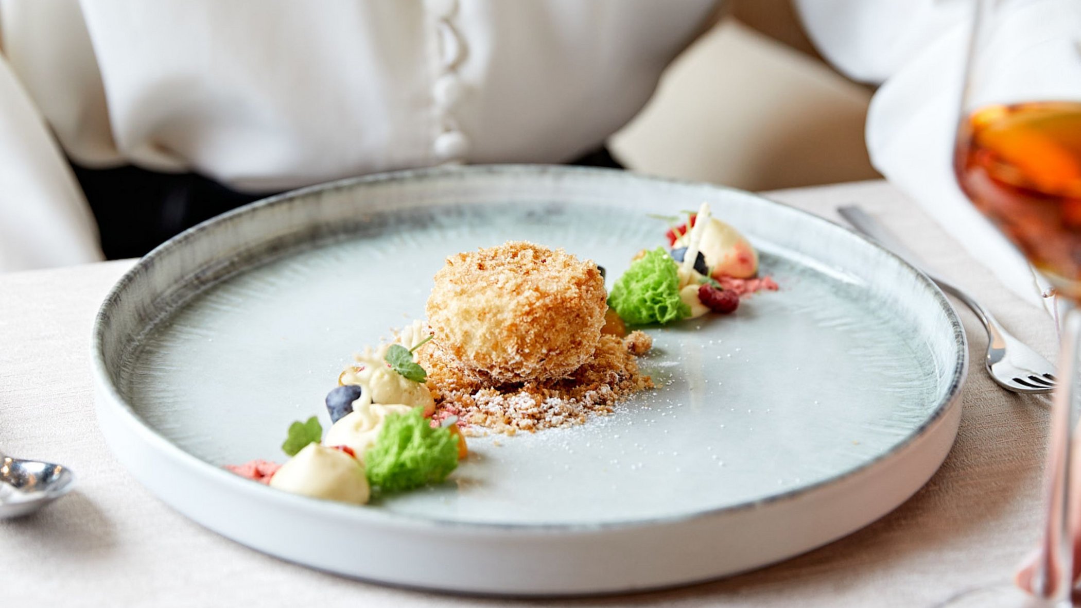 Vacanze in Tirolo all’insegna del gusto Dessert moderno con biscotto croccante e decorazioni di crema sul piatto