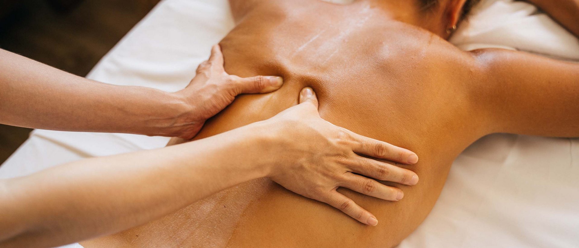 Spa-Behandlungen für Körper und Geist Frau erhält eine Rückenmassage auf einer weißen Liege