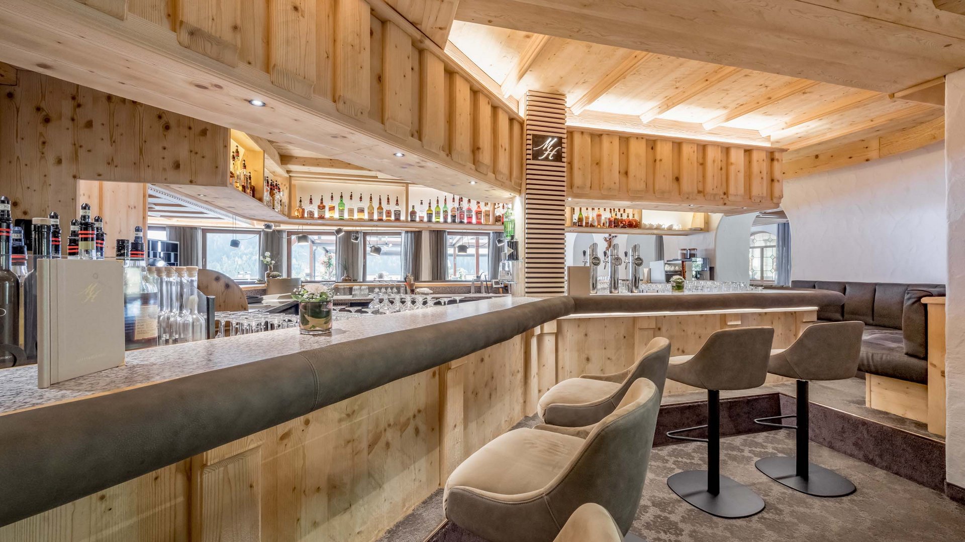 Stubaital: our hotel with a pool Cozy bar with wooden furnishings and high bar stools