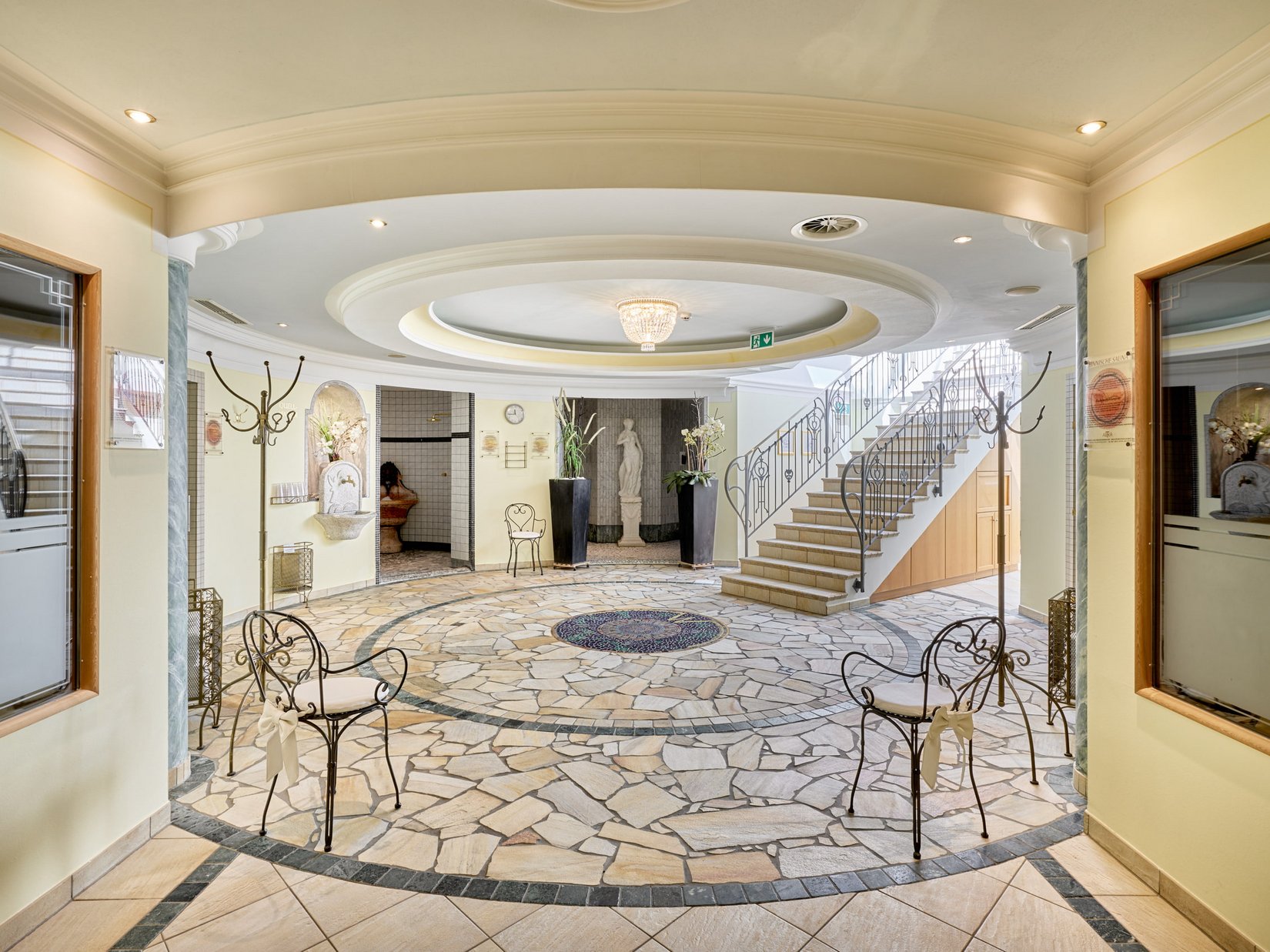 Stubaital: our hotel with a pool Bright wellness area with mosaic floor, stairs, and statues