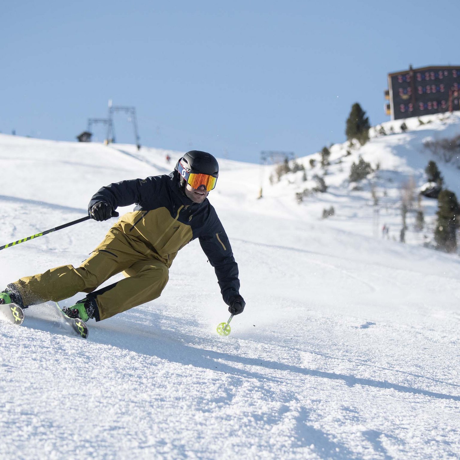 Der Stubaier Gletscher Skifahrer in brauner Jacke fährt auf einer verschneiten Piste bei sonnigem Wetter