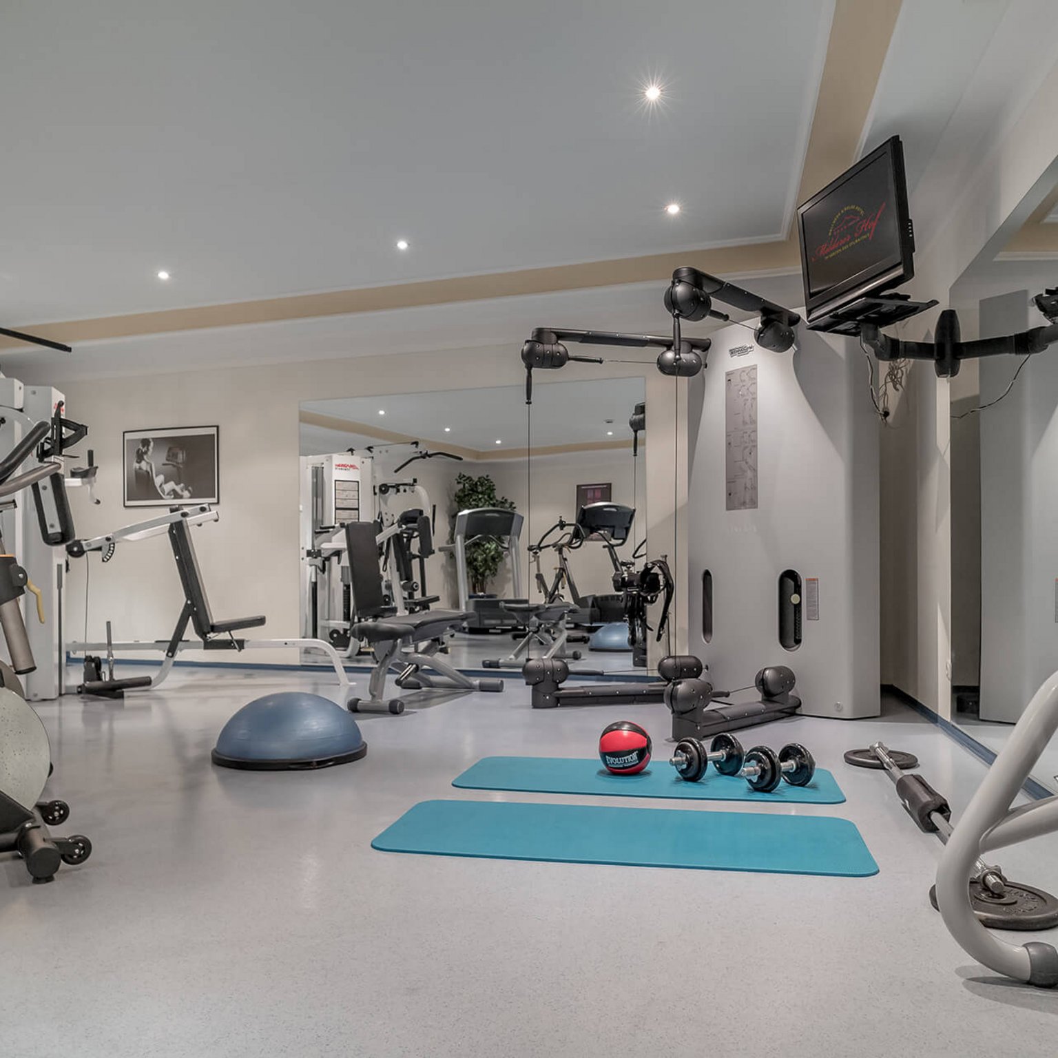 Hof wellness holiday: the Marienbad spa Modern gym with equipment, dumbbells, mats, and mirrored wall