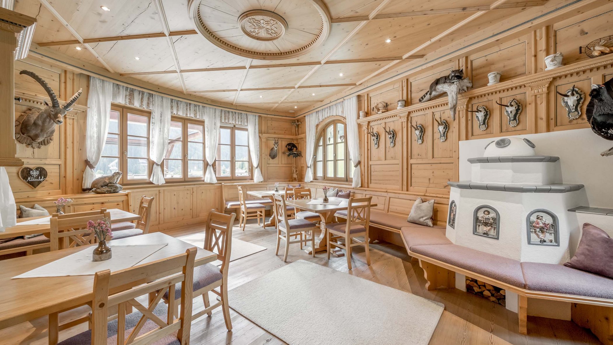 Hotel im Stubaital nahe Fulpmes Gemütlicher Gastraum mit Holzmöbeln und traditionellen Jagdtrophäen an der Wand