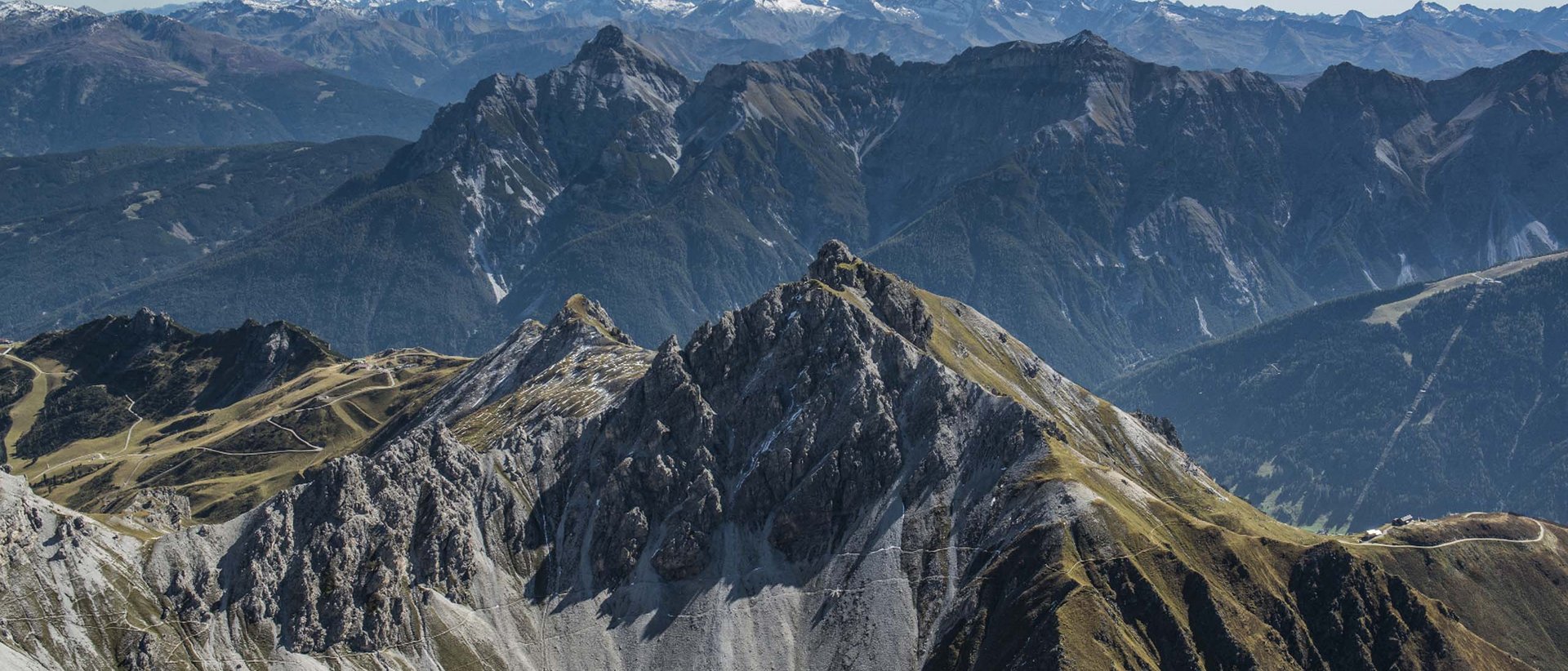 Die Naturschauplätze Berglandschaft mit steilen Felsen und Gipfeln unter blauem Himmel
