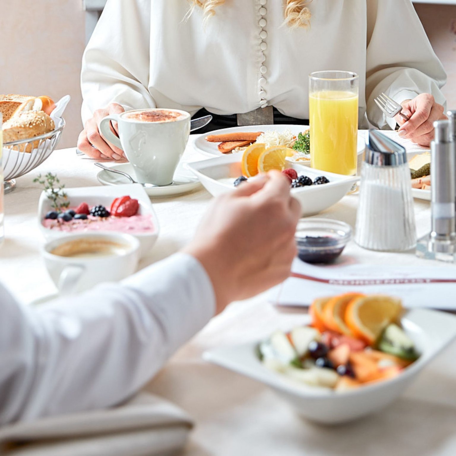 Vacanze in Tirolo all’insegna del gusto Persone che fanno colazione con frutta, succo, caffè e dolci