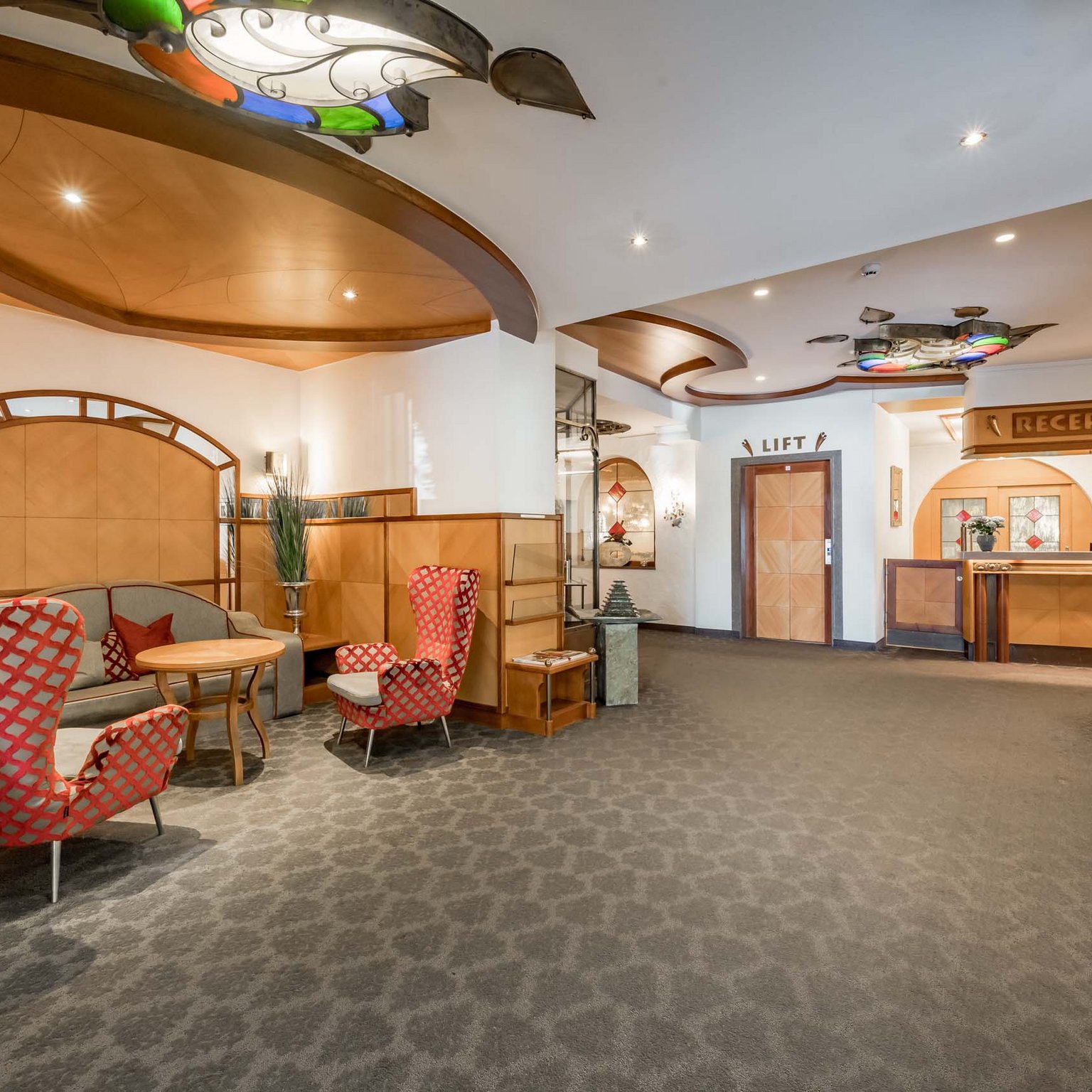 Offerte per una vacanza in Austria da sogno Reception dell'hotel con zona salotto e ascensore in design moderno con dettagli in legno