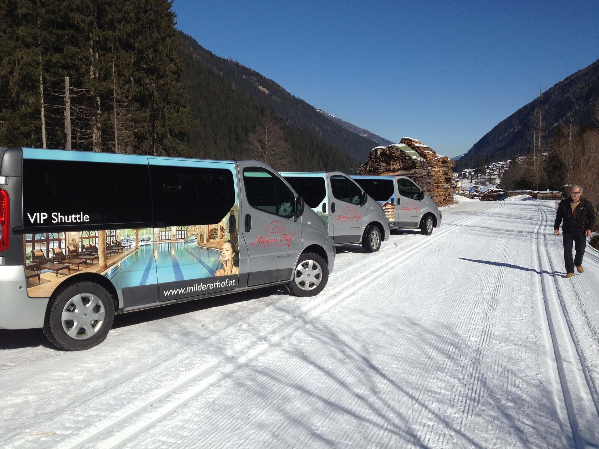 Hotel im Stubaital nahe Fulpmes VIP Shuttle Vans in verschneiter Berglandschaft mit Person am Straßenrand