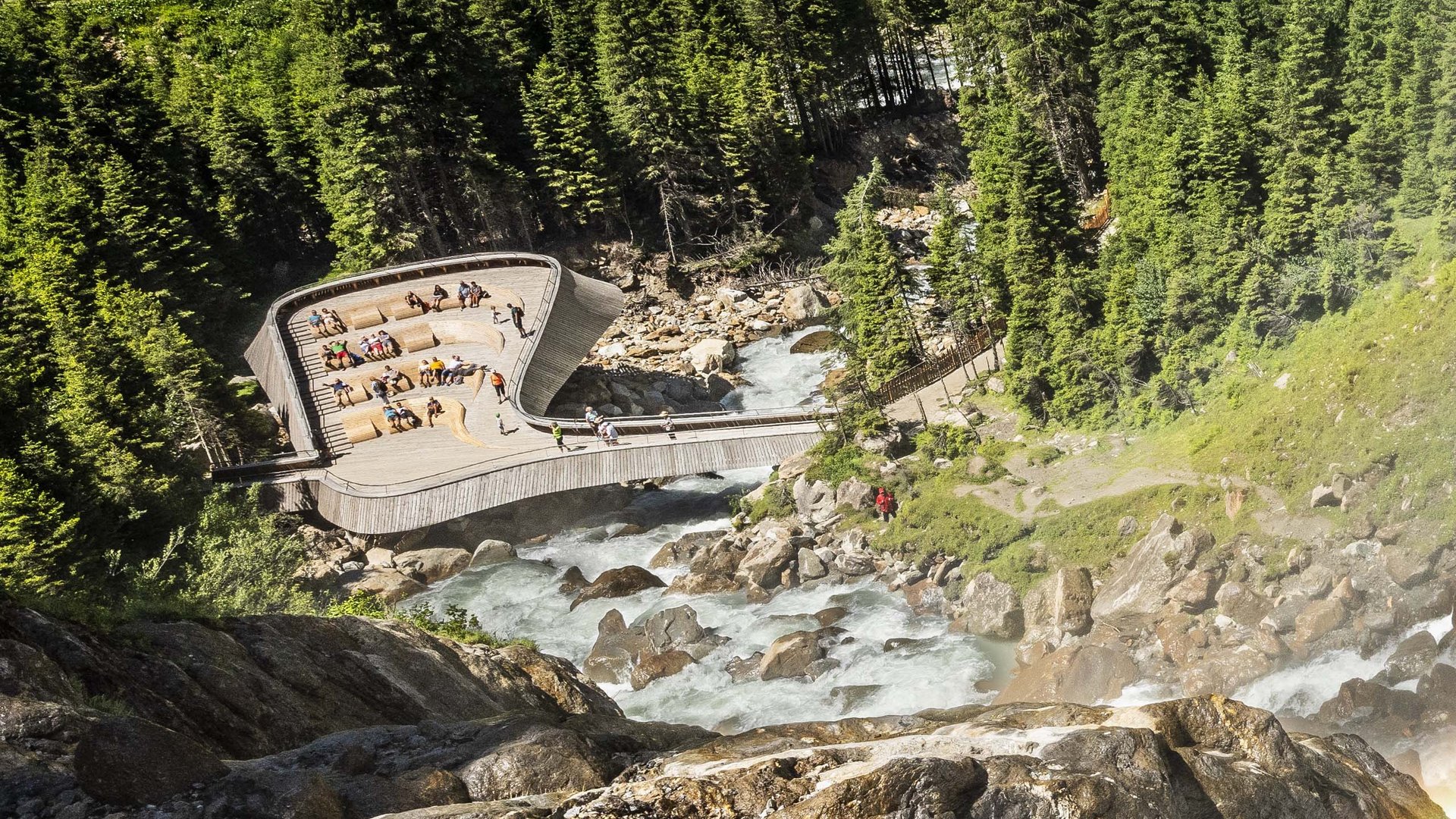 In Stubaital ci son mille cose da fare Punto panoramico sopra un torrente in montagna con bosco e visitatori