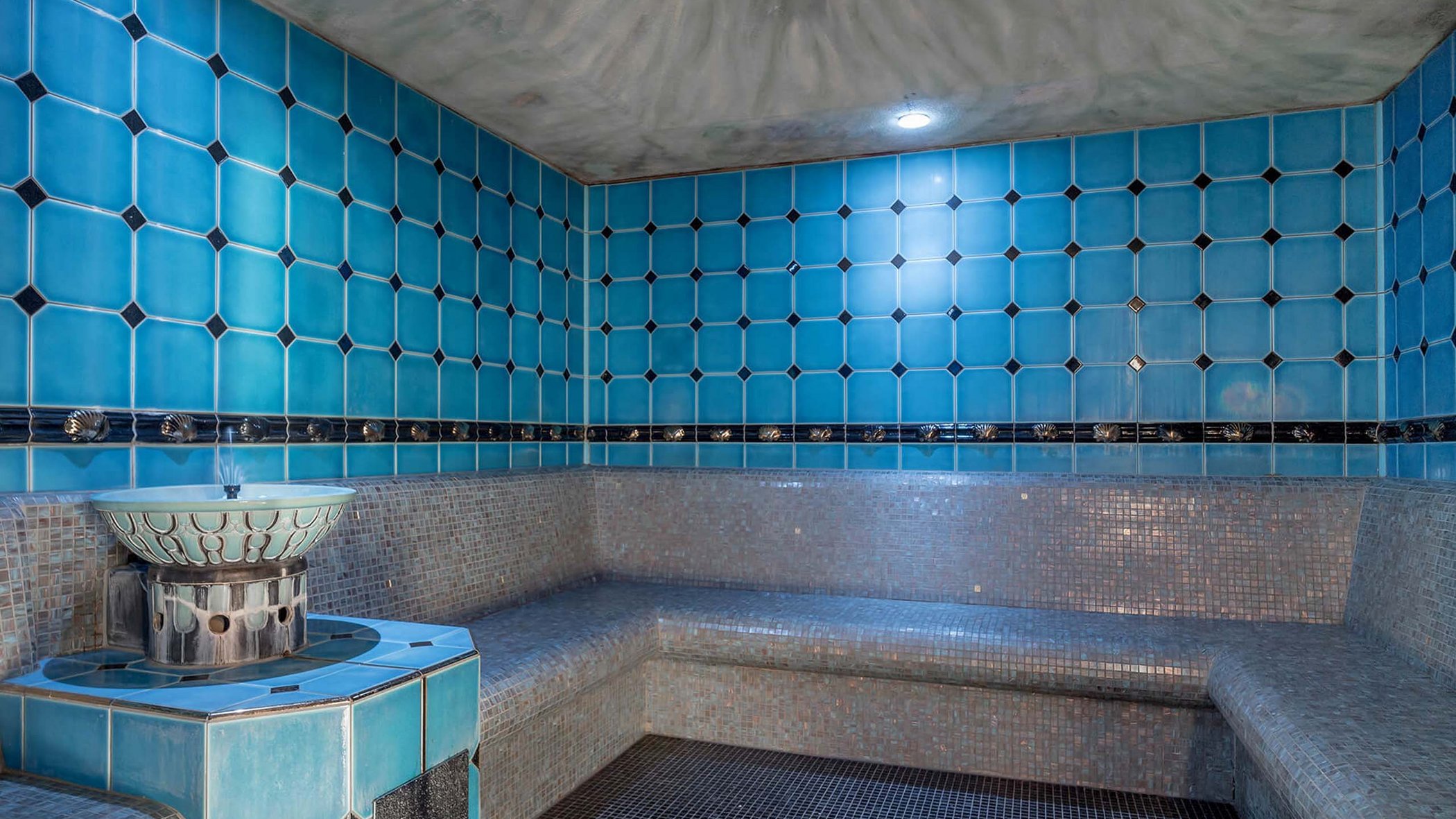 Off to the wellness hotel in Stubaital! Interior of a traditional steam room with blue and gray tiles