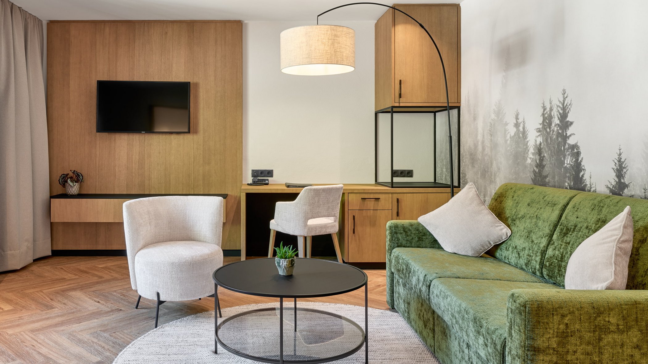 Ecco il nostro hotel: lo Stubai vi aspetta Soggiorno moderno con divano verde, sedie bianche e rivestimento in legno