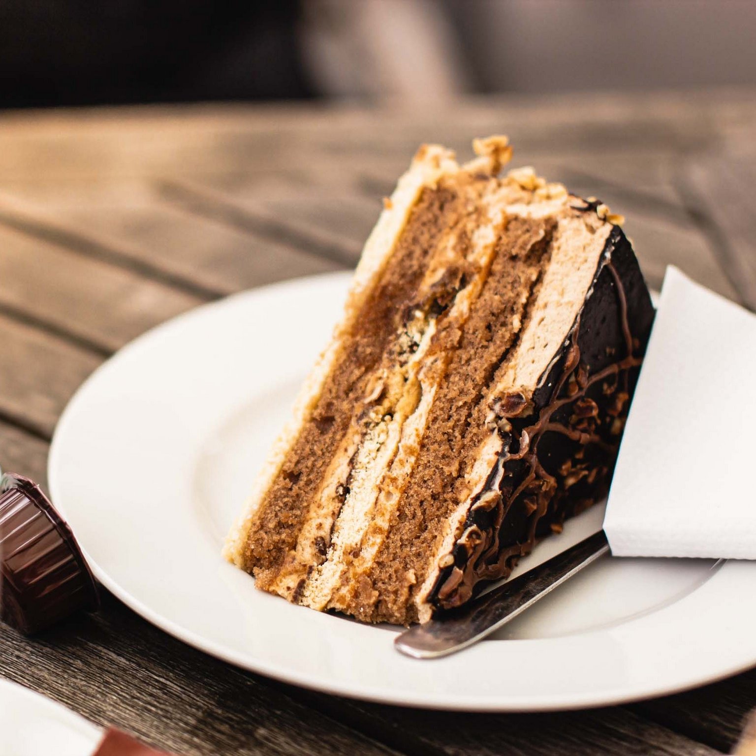 Hotels/Tyrol: 4-star superior holidays A slice of chocolate cake on white plate with coffee in the foreground