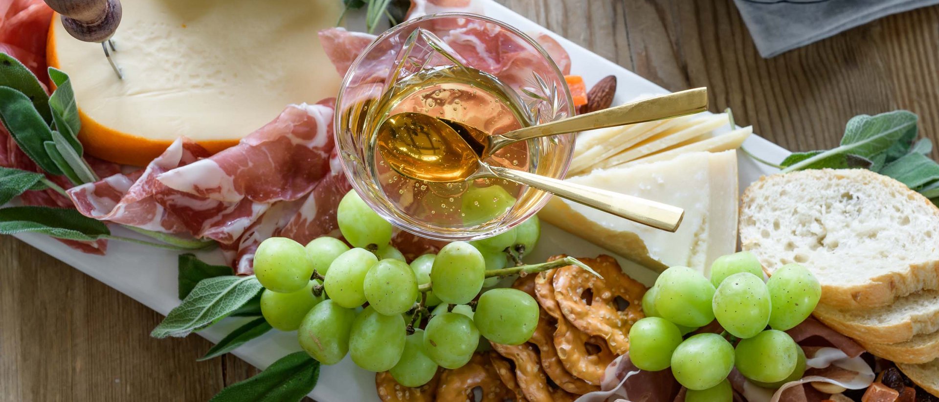 Los geht die Tour! Brett mit Käse, Schinken, Trauben, Brezeln und Honig in Glas