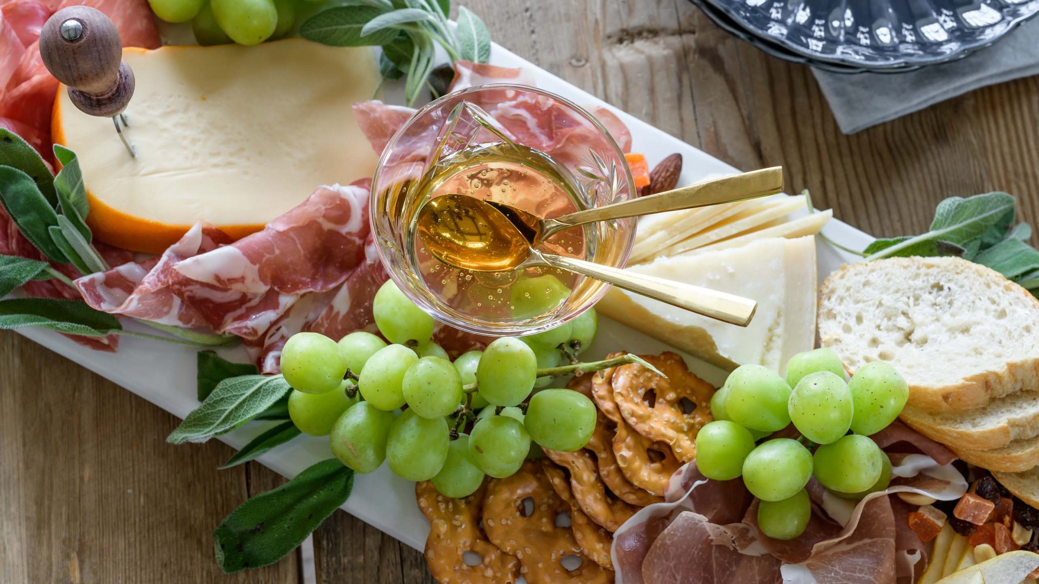 Hotels/Tyrol: 4-star superior holidays Platter with cheese, ham, grapes, pretzels, and honey in a glass
