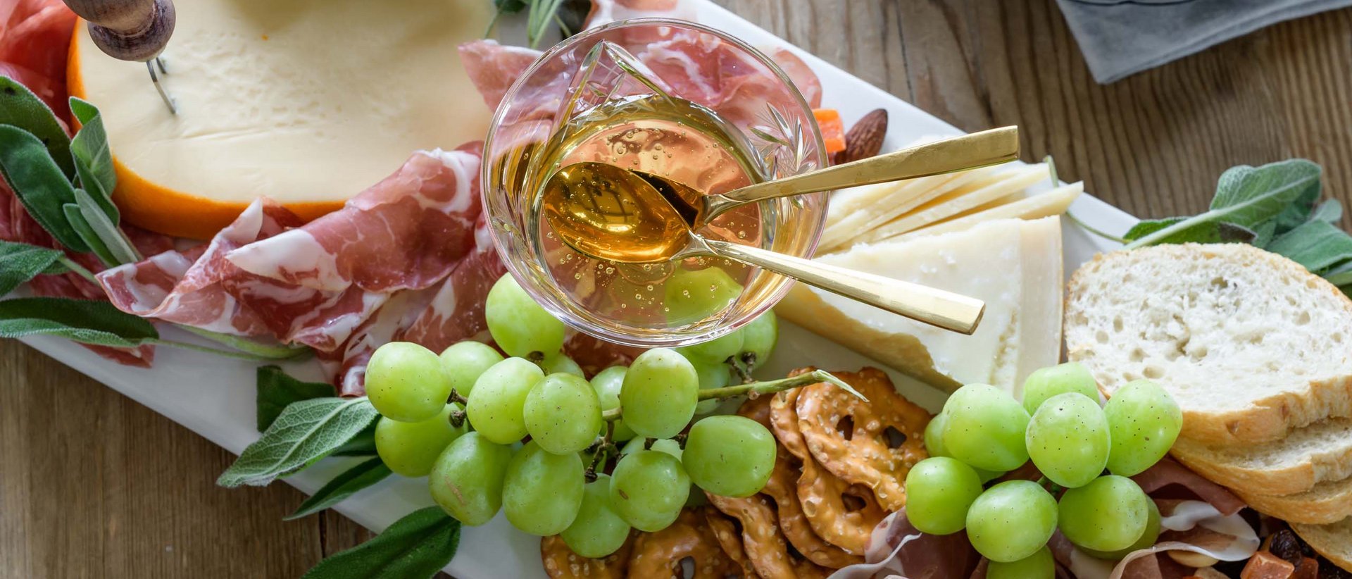 Los geht die Tour! Brett mit Käse, Schinken, Trauben, Brezeln und Honig in Glas