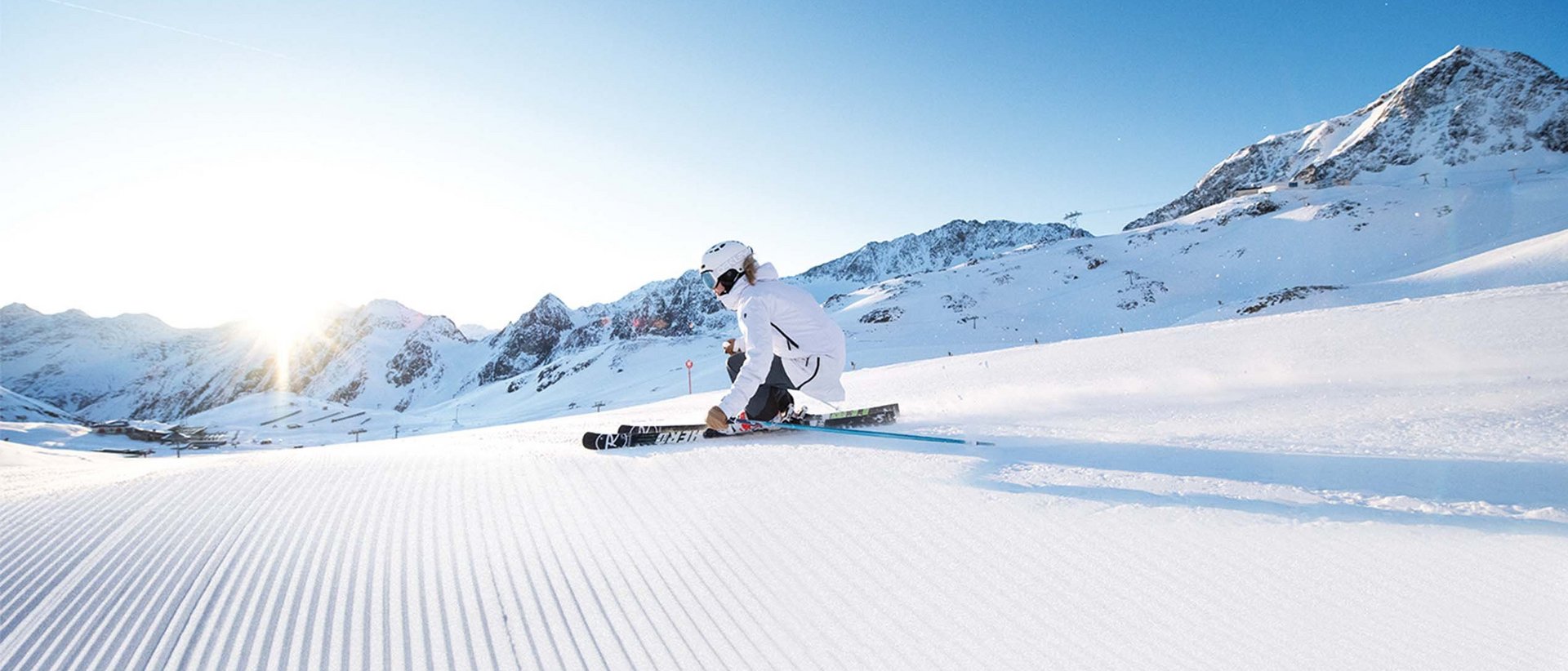 Wintererlebnisse in der Gletscherwelt Skifahrer in weißer Kleidung fährt an sonnigem Tag auf frischem Schnee