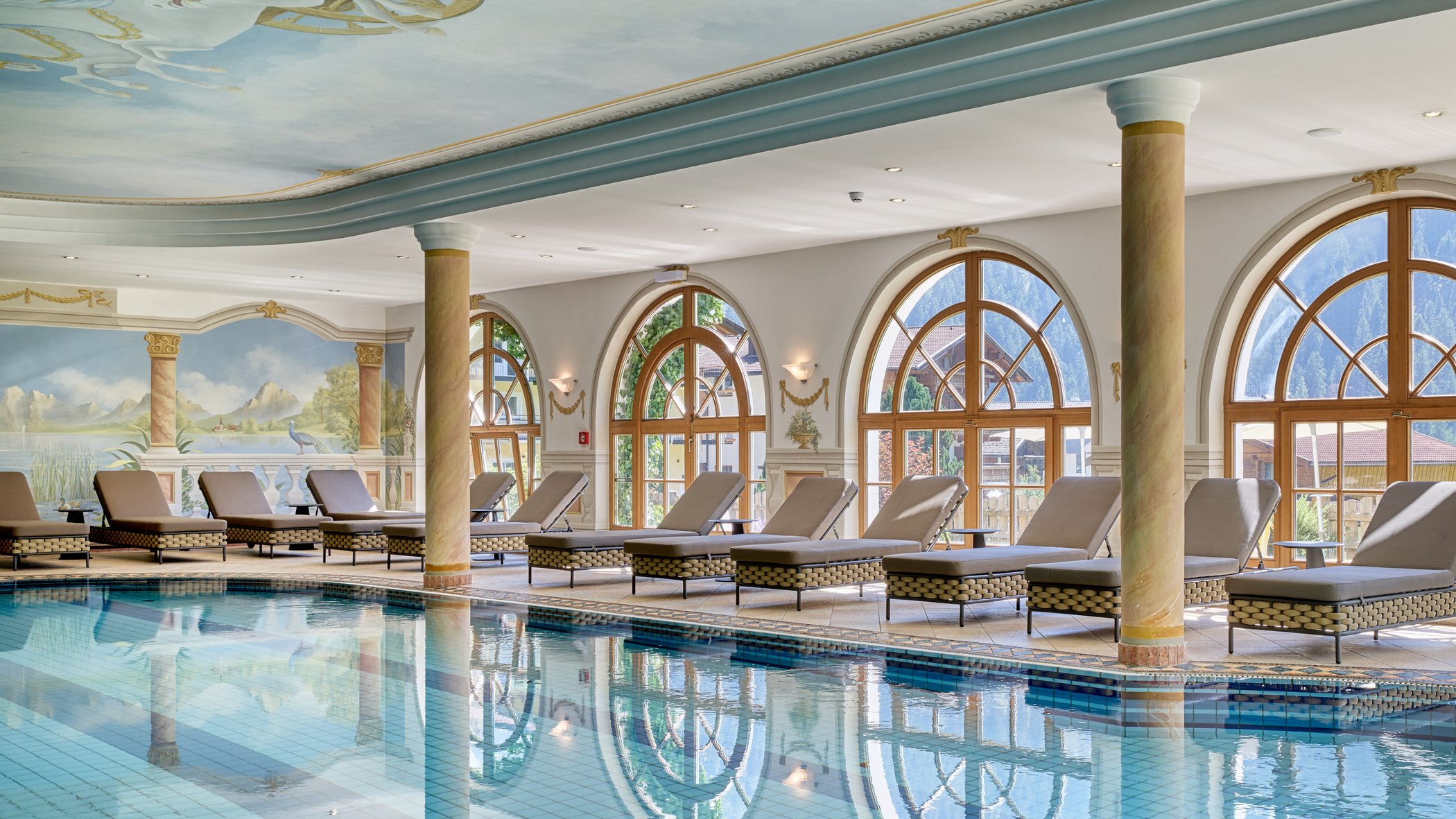 Stubai: l’hotel con piscina che cercavate è qui Piscina interna elegante con lettini e grandi finestre con vista sulle montagne