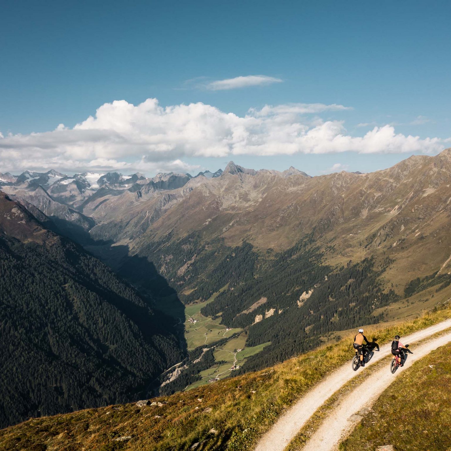 Your hotel in Neustift in Stubaital Two cyclists on a mountain trail with alpine scenery under a clear sky
