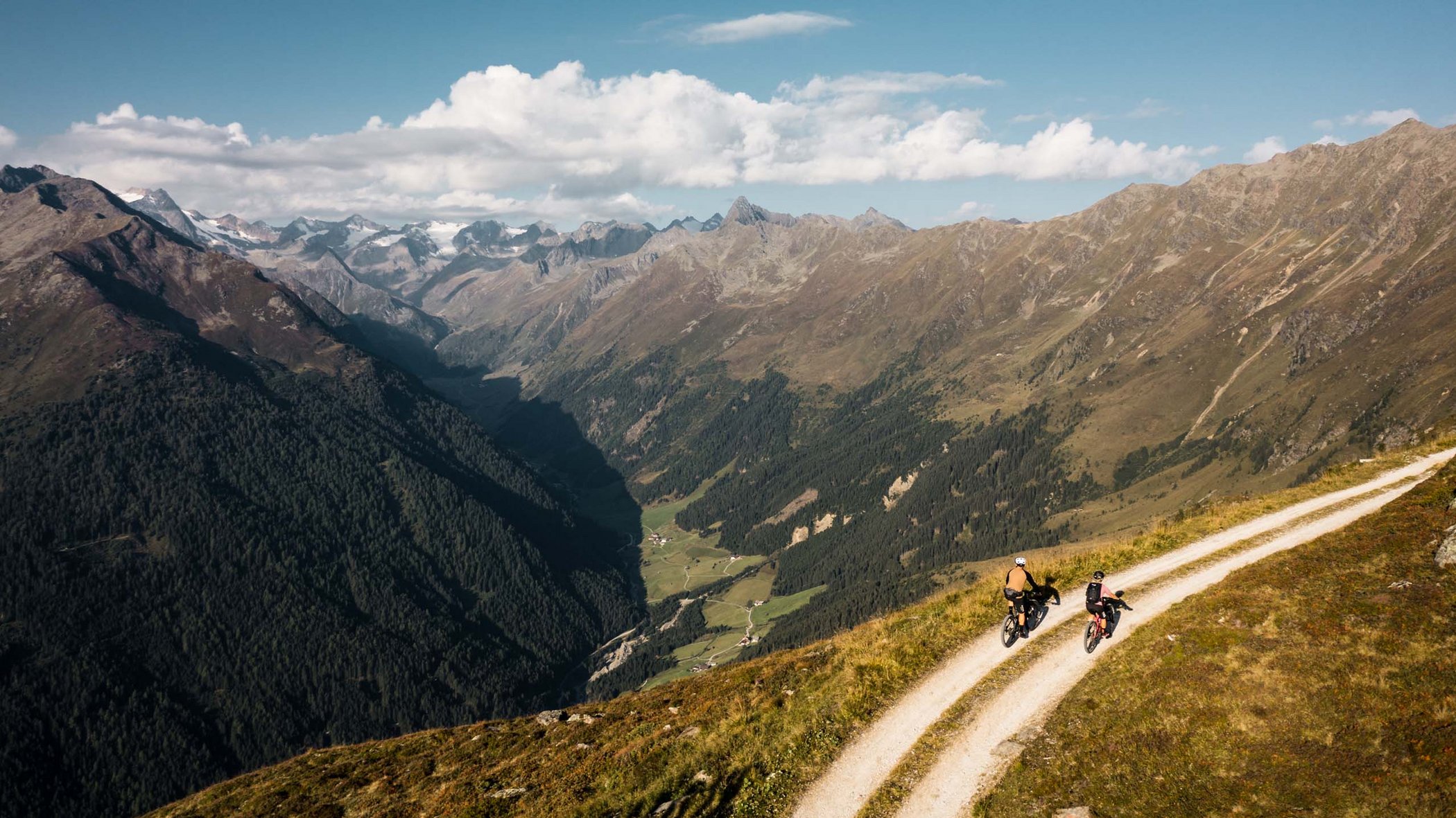 Stubaital: Hiking in summer Two cyclists on a mountain trail with alpine scenery under a clear sky