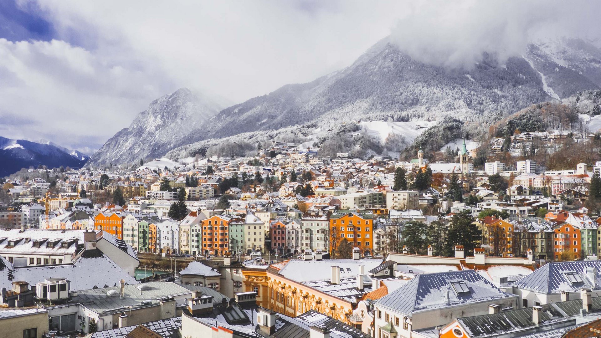 Things to do in Stubaital Snow-covered city in front of mountains with colorful houses and cloudy sky