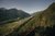 Luftaufnahme eines Hängebrücke-Wanderwegs im Wald mit Bergtal und Dorf im Hintergrund