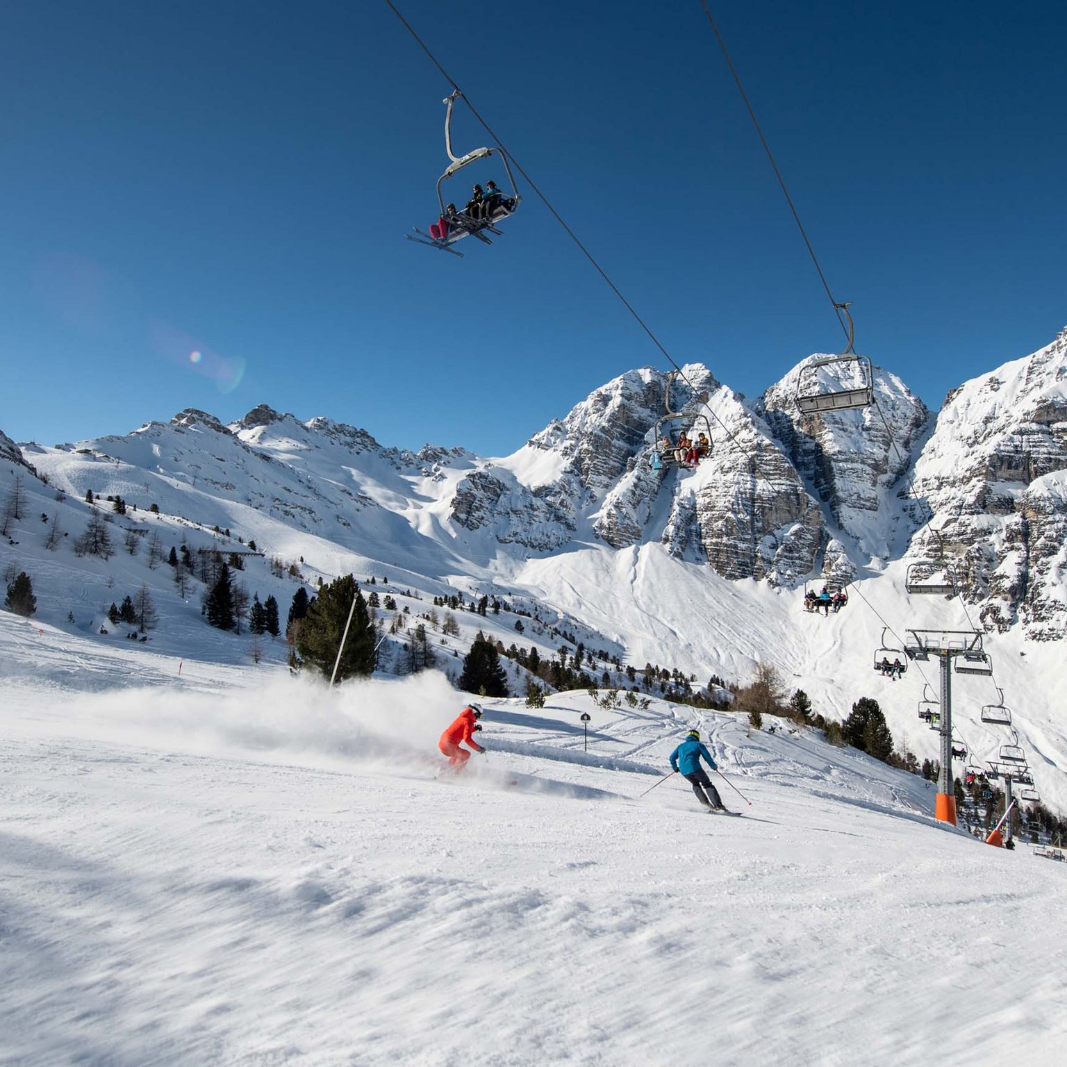 Skiing in Stubaital: offers Two skiers on snowy slope with chairlift and mountains in the background