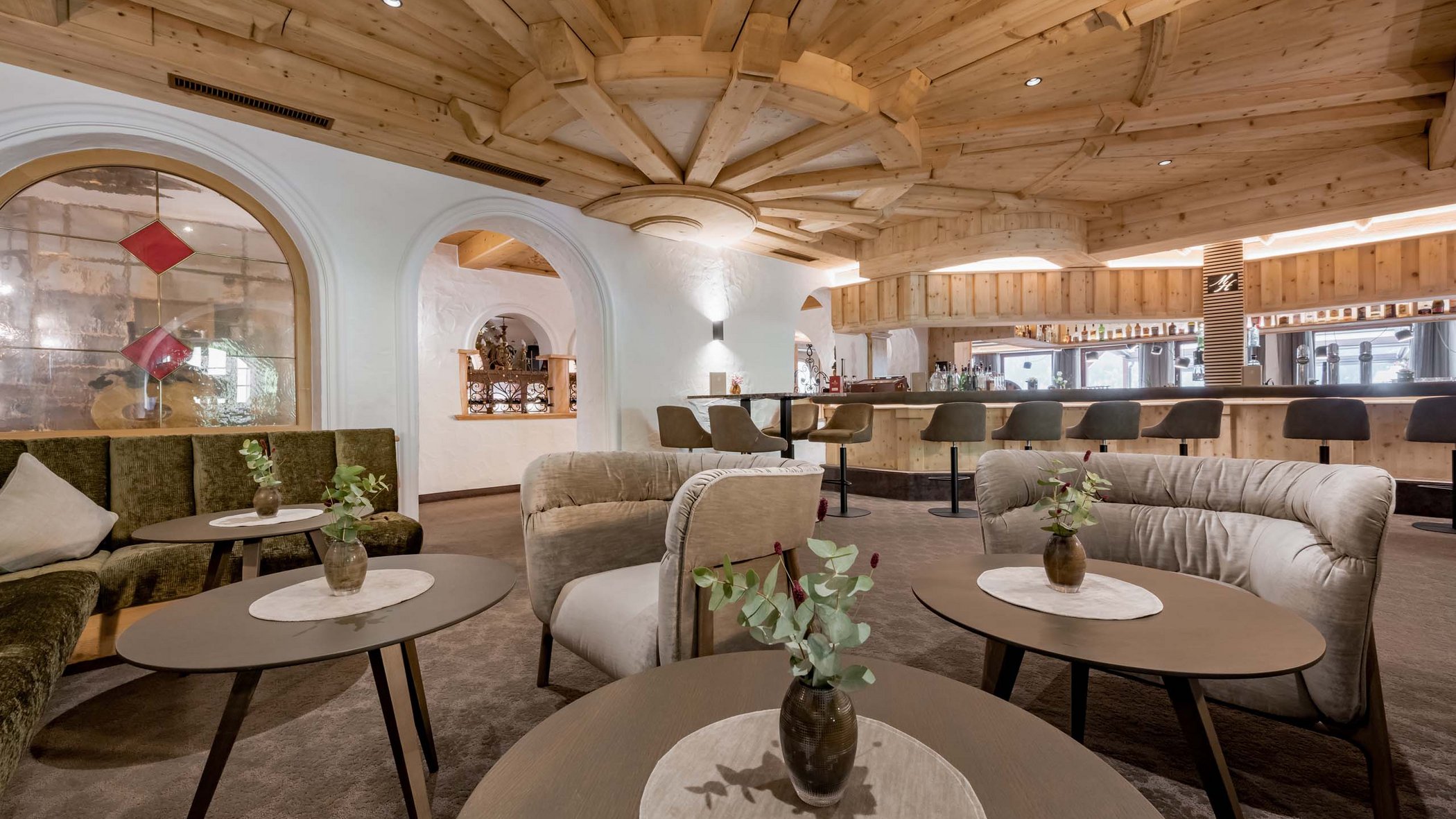 Offerte per una vacanza in Austria da sogno Bar accogliente con soffitto in legno, divani e tavoli con vasi decorativi