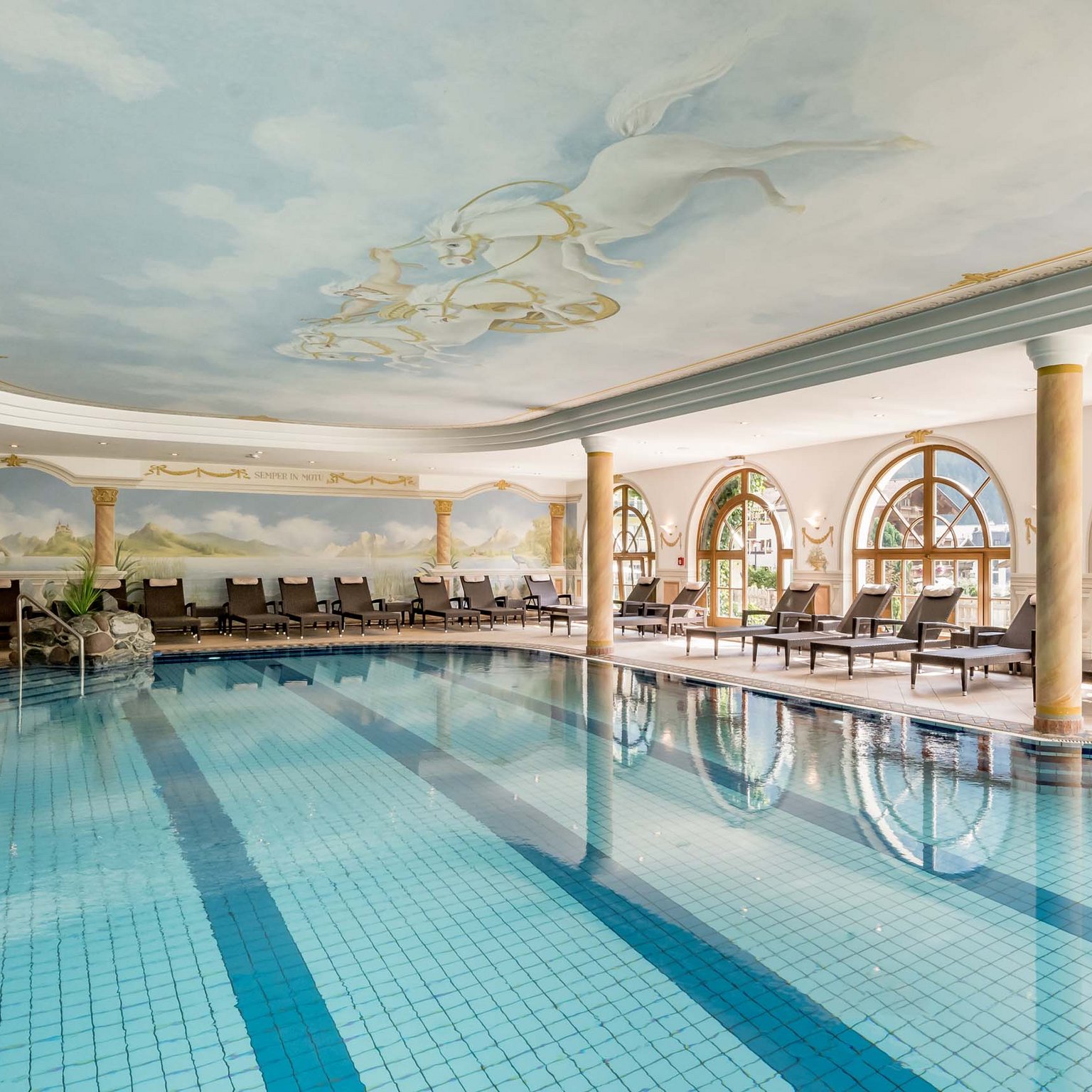 Offerte per una vacanza in Austria da sogno Piscina coperta con soffitto dipinto e lettini accanto a grandi finestre