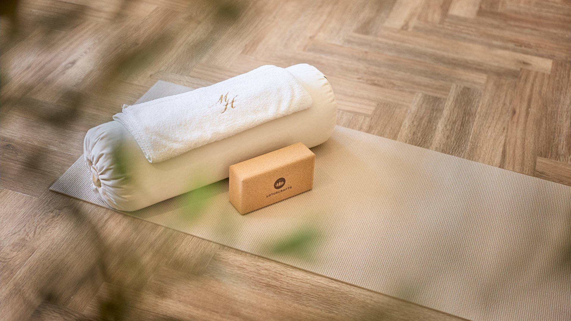 Stubai: l’hotel con piscina che cercavate è qui Tappetino yoga con cuscino, asciugamano e blocco in sughero su pavimento in legno