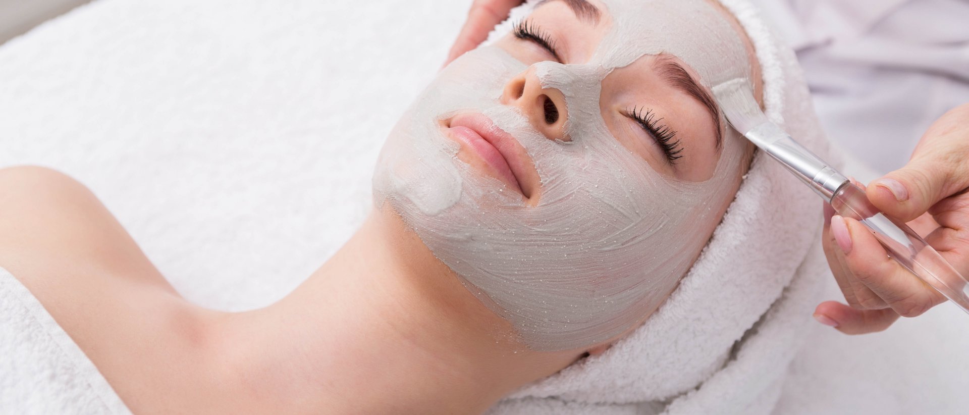 Entspannung im Milderer Hof Frau bekommt Gesichtsmaske bei Wellnessbehandlung