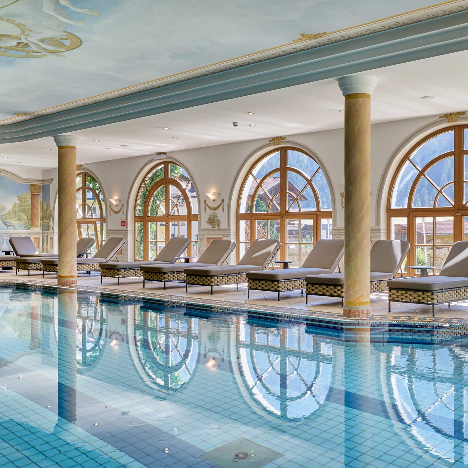Stubai: l’hotel con piscina che cercavate è qui Piscina interna luminosa con lettini e grandi finestre con vista sulle montagne