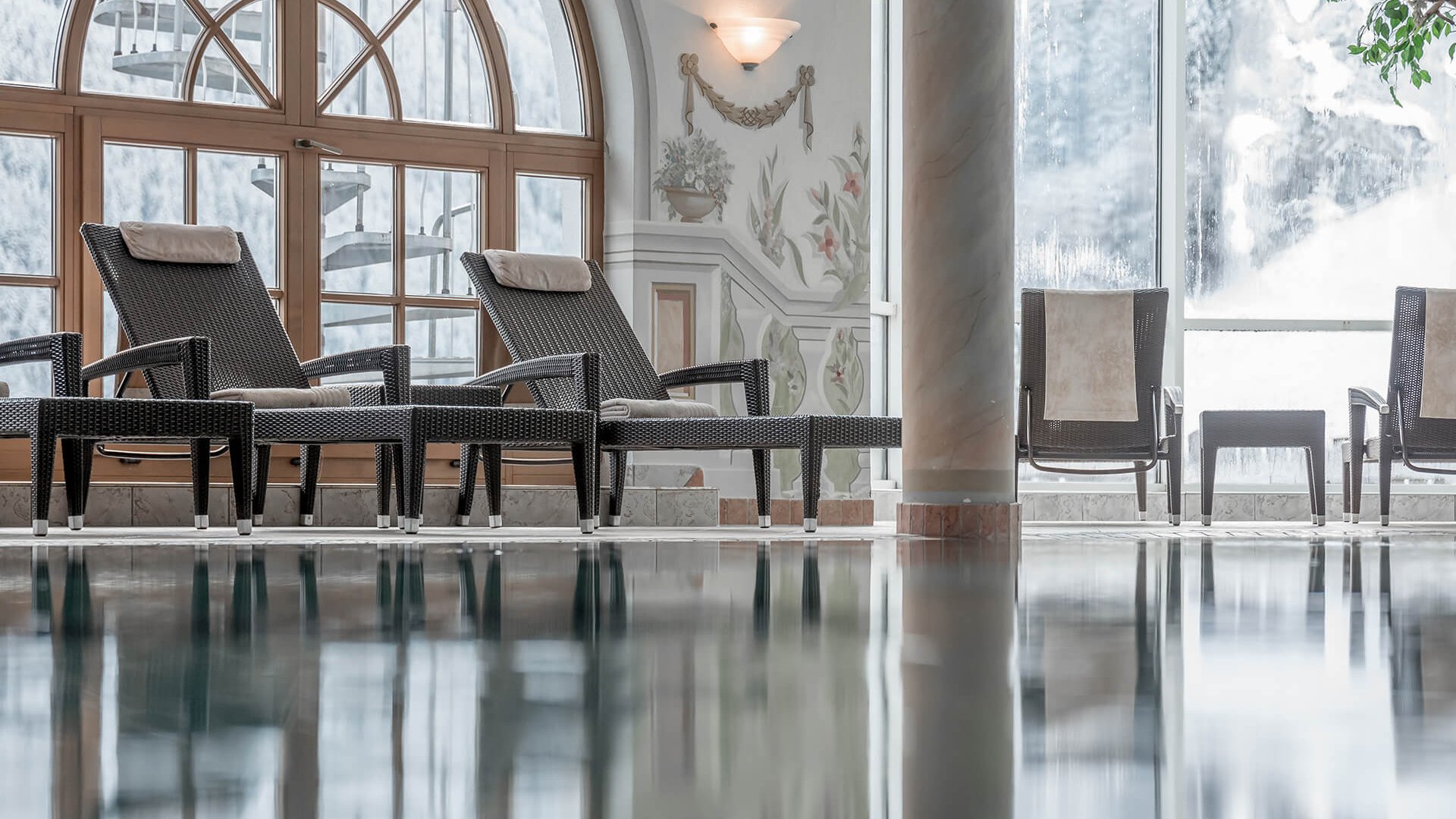 Stubaital: our hotel with a pool Lounge chairs beside a calm indoor pool in an elegant spa area