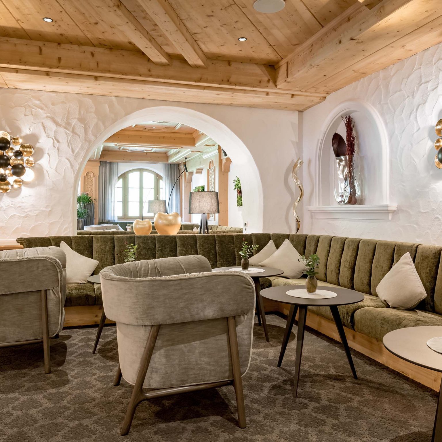 Hotel in Stubaital near Fulpmes Cozy hotel lounge with green upholstered seating and stylish wooden ceiling