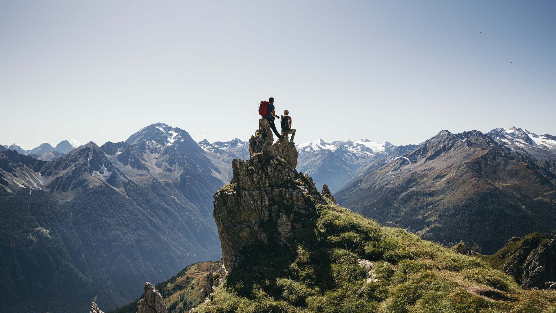 Stubaital: Hiking in summer Two hikers on a rock with a view of snow-capped mountains