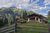 Infos aus Neustift: Hotel-News! Almhütte mit Holzställen vor bewaldeten Alpenbergen