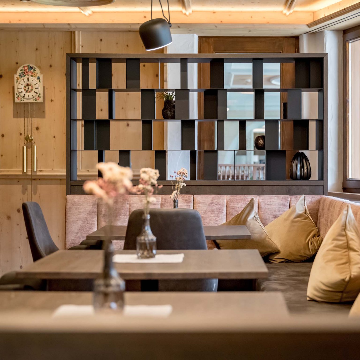 Off to the wellness hotel in Stubaital! Cozy dining area with wooden walls, bench seating, and decorative pillows