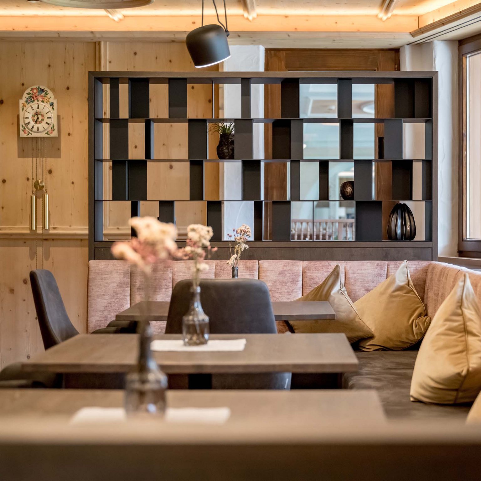 Off to the wellness hotel in Stubaital! Cozy dining area with wooden walls, bench seating, and decorative pillows