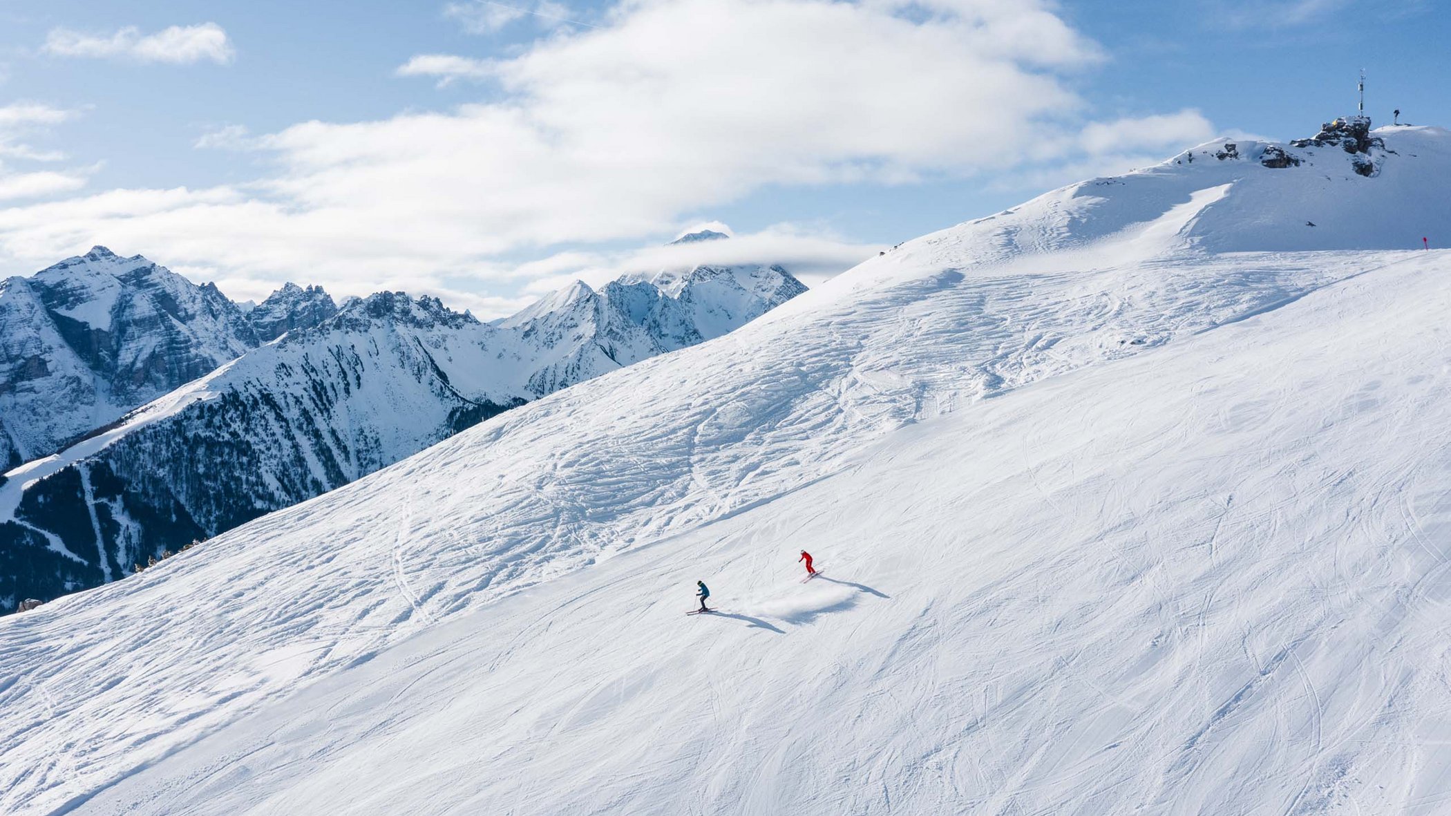 Skiing in Stubaital: offers Two skiers on snowy mountain slope with Alps in the background