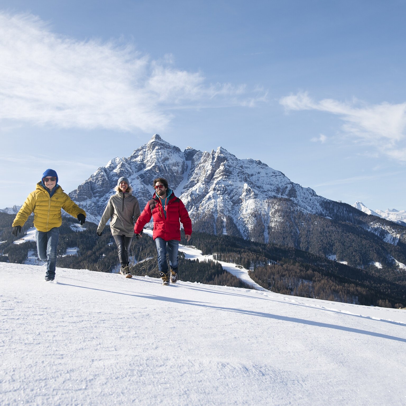Der Stubaier Gletscher Drei Personen wandern im Schnee vor verschneiten Bergen am sonnigen Tag